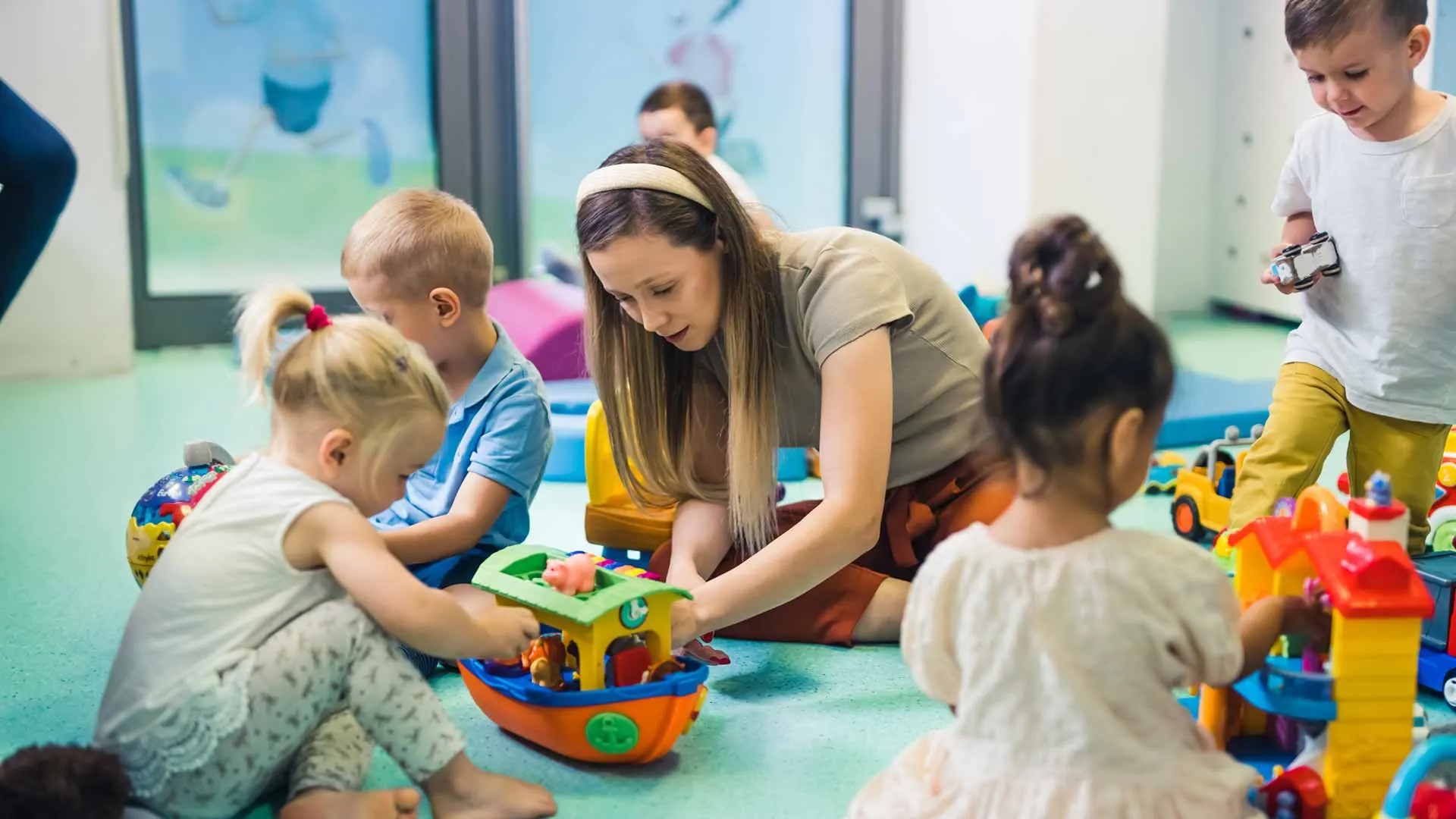 Professionnelle de la petite enfance accompagnant des enfants dans un espace de jeux